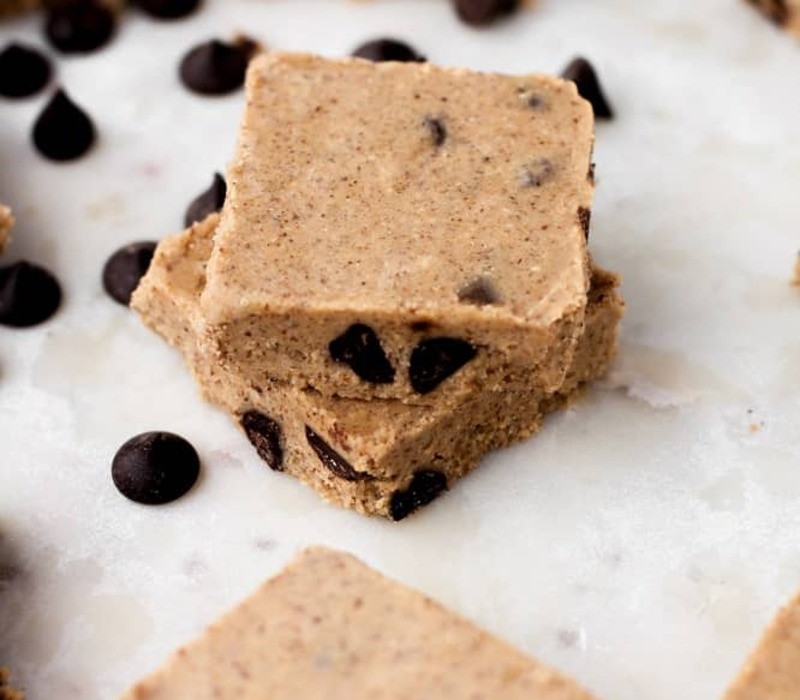 The sweetened shredded coconut condensed milk with sugar, as well as vanilla essence, should all be combined in a mixing dish. Stir everything up thoroughly Make a small rectangle shape the size of an Almond Joy bar out of roughly 2 teaspoons of the coconut mixture Place a full almond on top of each rectangle of coconut. On a baking sheet covered with paper, arrange the bars To firm up the bars, put the baking sheet inside the freezer for one hour Melt the dark chocolate chips using a double boiler or even the microwave after the bars are set If you're using a microwave, melt the chocolate in 30-second bursts, stirring after each one After removing the bars from the freezer, fully cover each one by dipping it with a fork into the melted chocolate When putting the bars back onto a parchment-lined baking sheet, let any extra chocolate drip off Place the bars in the freezer again for an additional hour to solidify the chocolate once it has been applied to all of them Your homemade Almond Joy calories bars seem to be ready to eat once the chocolate has solidified. For up to a week, keep them in the refrigerator in an airtight container